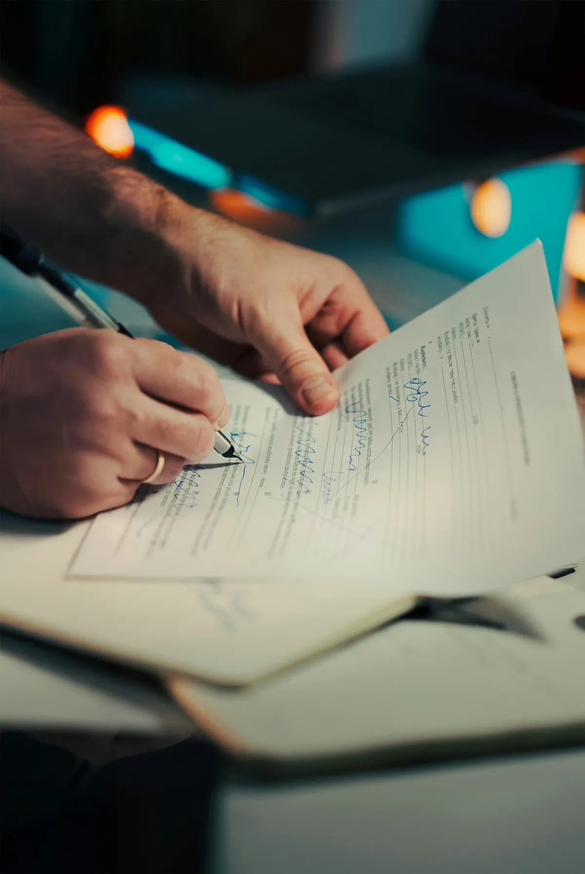 Close-up of hands signing and filling out a document